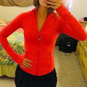 Define Jacket is orange/red color with thumb holes